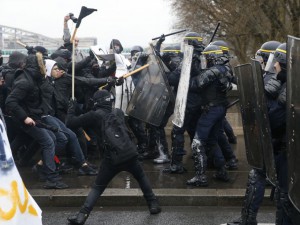 French riot police clash with union members and students demonstrating against labour law reforms gathered close to the Gare de Lyon train station in the French capital Paris on March 31, 2016. France faced fresh protests over labour reforms just a day after the beleaguered government of President Francois Hollande was forced into an embarrassing U-turn over constitutional changes. AFP PHOTO / THOMAS SAMSON / AFP / THOMAS SAMSON